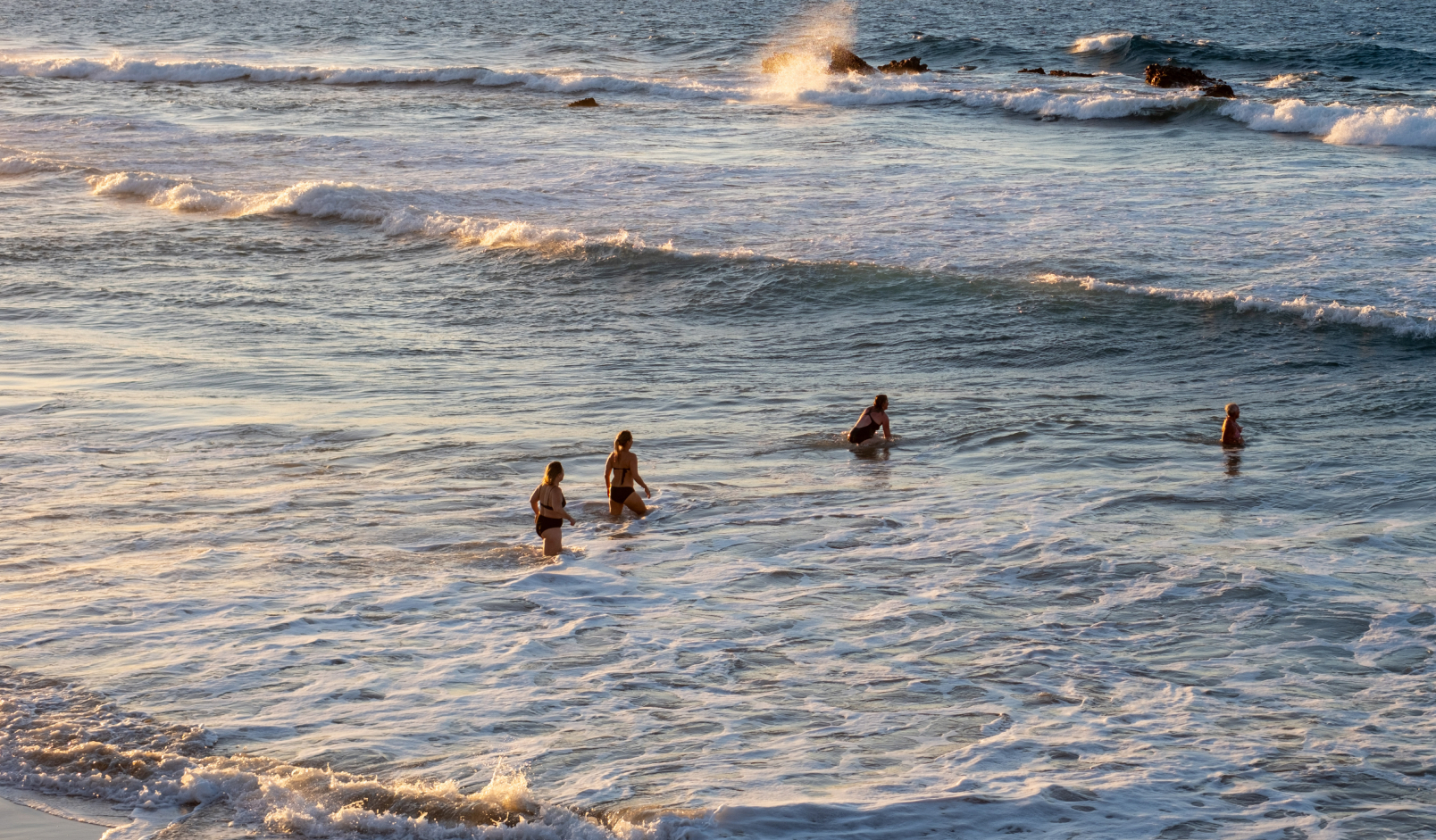 Menschen im Meer bei warmem Abendlicht
